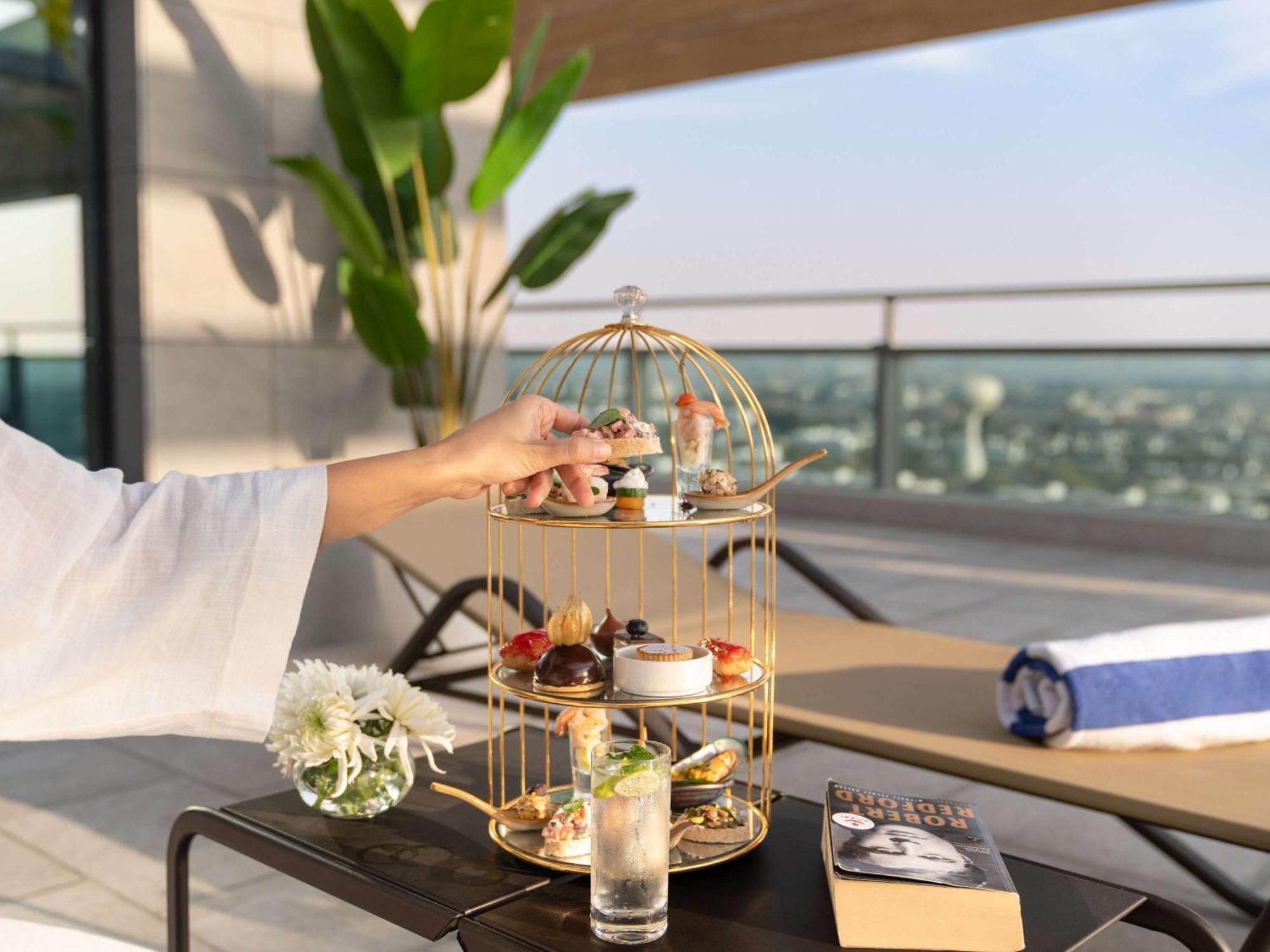 Swissotel Living Jeddah Bagian luar foto Afternoon tea at the pool deck